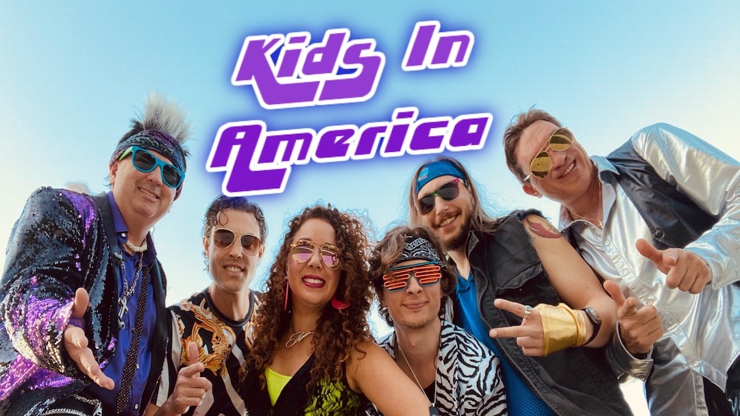 Members of the 80s Tribute Band Kids in America pose for a picture beneath their logo